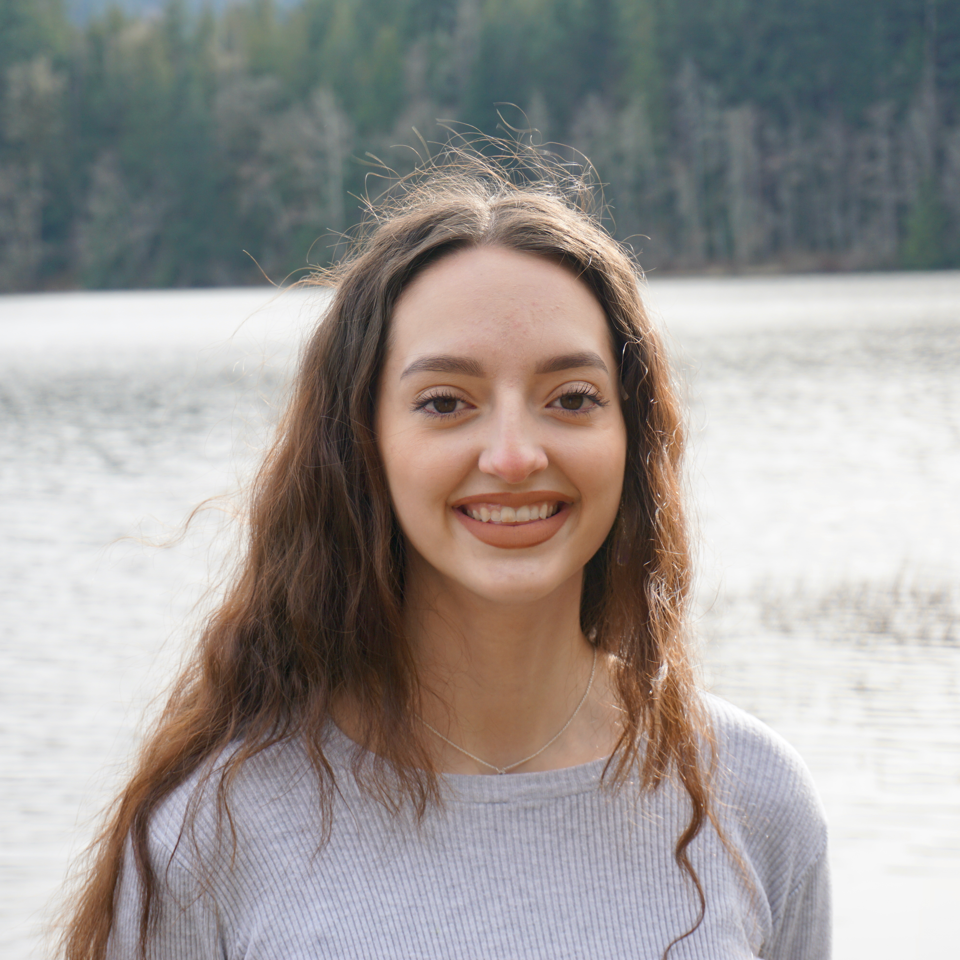 Graduation self portrait. Me smiling with Lake Padden and green trees in the background.